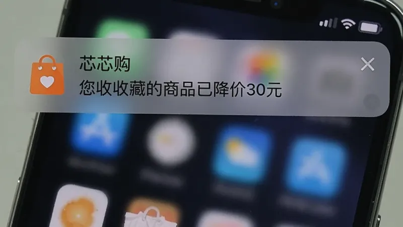 一张手机通知栏截图，显示“芯芯购”发来的降价提醒通知，内容为“您收藏的商品已降价30元”，通知图标为橙色购物袋样式，背景是深色手机壁纸，整体画面真实自然，重点突出通知内容，干净整洁