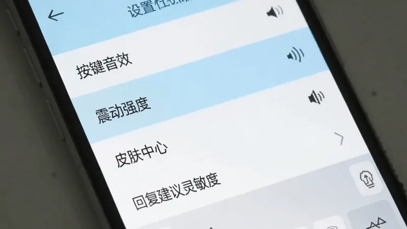 知心键盘设置界面截图示意图,手机屏幕显示着键盘的设置菜单,菜单项包括“按键音效”、“震动强度”、“皮肤中心”、“回复建议灵敏度”等选项,界面风格简洁,以白色和浅蓝色为主,布局清晰,画质干净,无多余元素