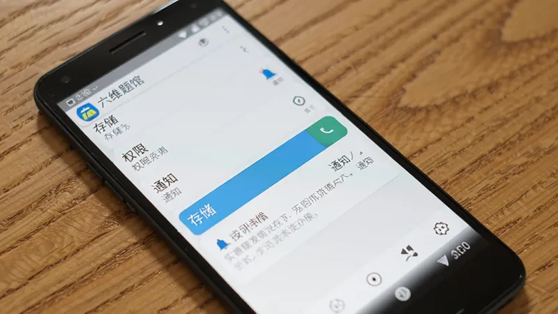 一部安卓手机放在桌面上，屏幕上显示着“六维题馆”的应用信息页面，页面中有“存储”、“权限”、“通知”等选项，其中“存储”权限被高亮显示，背景是木质桌面，风格写实，画质清晰，无多余元素