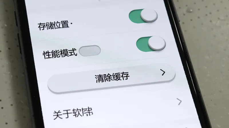 一张展示东朔办公设置界面的图片，主体是手机屏幕，布局为从上到下依次是存储位置选择、性能模式开关、清除缓存按钮、关于软件四个选项，排版为列表式，风格为极简工具风，细节上开关按钮有立体感，文字标签清晰，画质干净，无多余元素。