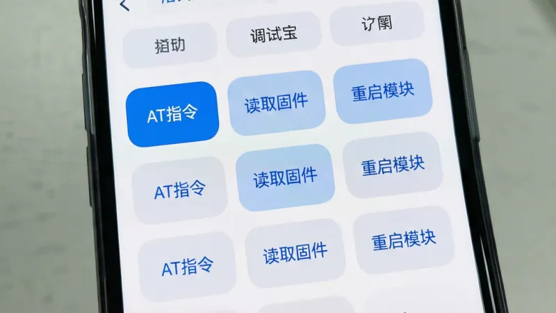 一张展示蓝牙调试宝快捷指令面板的图片。主体是手机屏幕，屏幕内是蓝牙调试宝的快捷指令界面，网格状排列着多个自定义按钮，按钮上写着“AT指令”、“读取固件”、“重启模块”等文字。布局为手机正面特写，排版整齐。风格为浅色简约风，白底蓝字。细节包括圆角矩形按钮、清晰的文字标签、顶部的分组标签页。画质高清，干净，无多余元素。