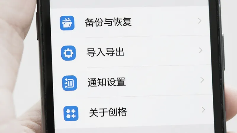创格应用内设置与帮助界面，手机屏幕显示设置菜单列表，包含备份与恢复、导入导出、通知设置、关于创格等选项，每个选项左侧有对应图标，界面风格简洁统一，灰白底色搭配蓝色图标，画质干净，无多余元素