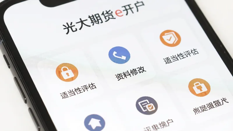 一张展示光大期货e开户软件业务办理页面的图片,手机屏幕中显示多个功能图标,包括密码重置、资料修改、适当性评估等,图标排列整齐,顶部有光大期货e开户文字,背景为白色,风格简洁明快,画质清晰