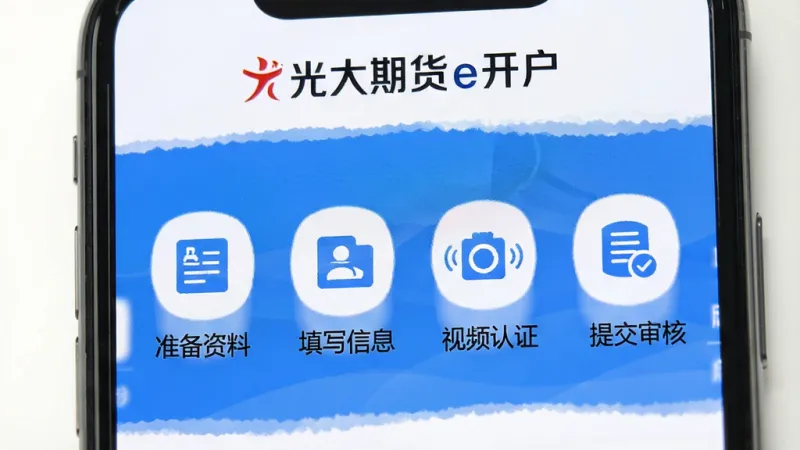 一张展示光大期货e开户软件操作步骤的图片,手机屏幕中显示开户流程的四个步骤图标,包括准备资料、填写信息、视频认证、提交审核,每个步骤下方有文字说明,屏幕上方有光大期货e开户文字标识,背景为白色,风格简洁清晰,画质干净