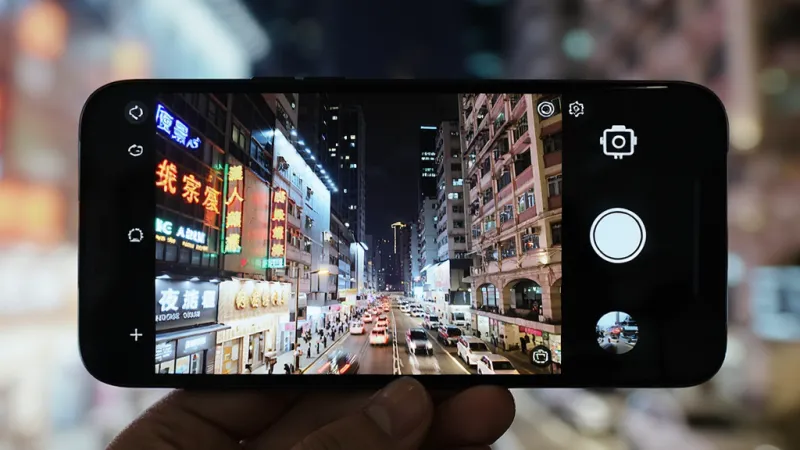 手机屏幕显示AI智能相机拍摄城市夜景的画面,画面中霓虹灯清晰不过曝,暗部建筑细节可见,屏幕上有夜景模式图标,风格都市夜景,画质干净,图片中文字标注“AI智能相机