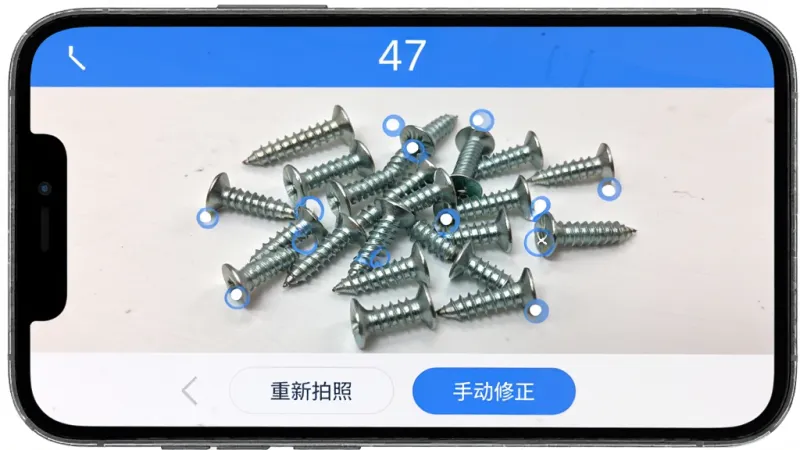 拍照扫描计数软件识别界面，手机屏幕显示一堆散落的螺丝钉，每个螺丝钉上都有一个小圆点标记，屏幕上方显示数字“47”，下方有“重新拍照”和“手动修正”两个按钮，蓝白配色，界面干净，风格简洁现代，画质清晰